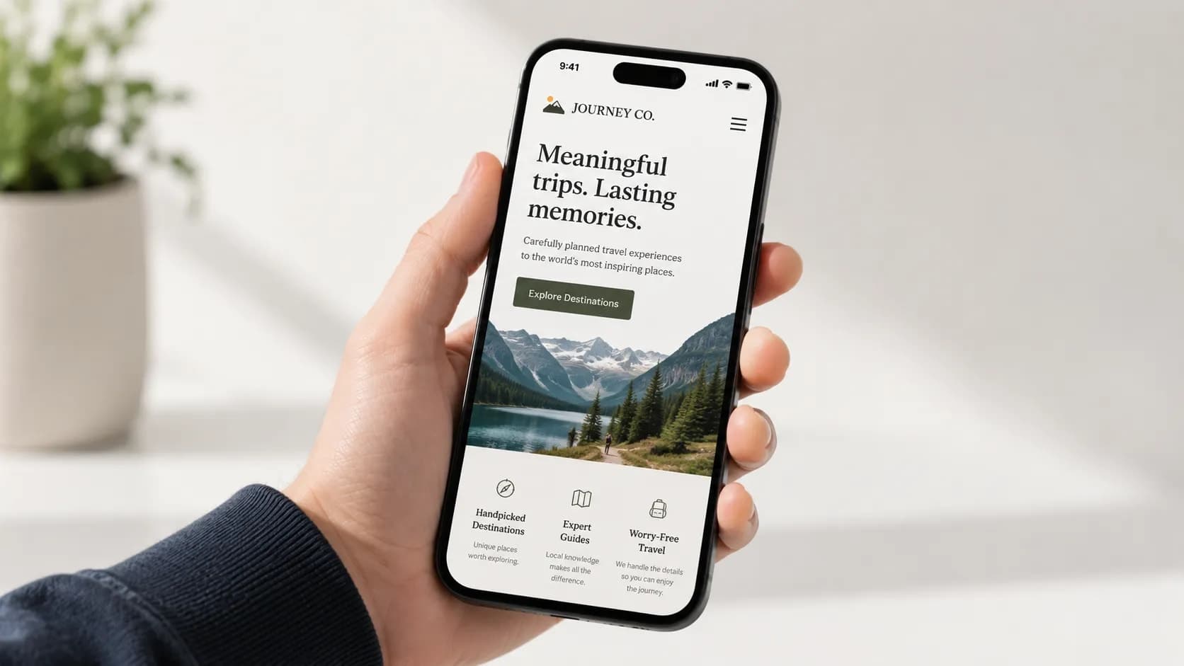 A hand holding a phone displaying a website.